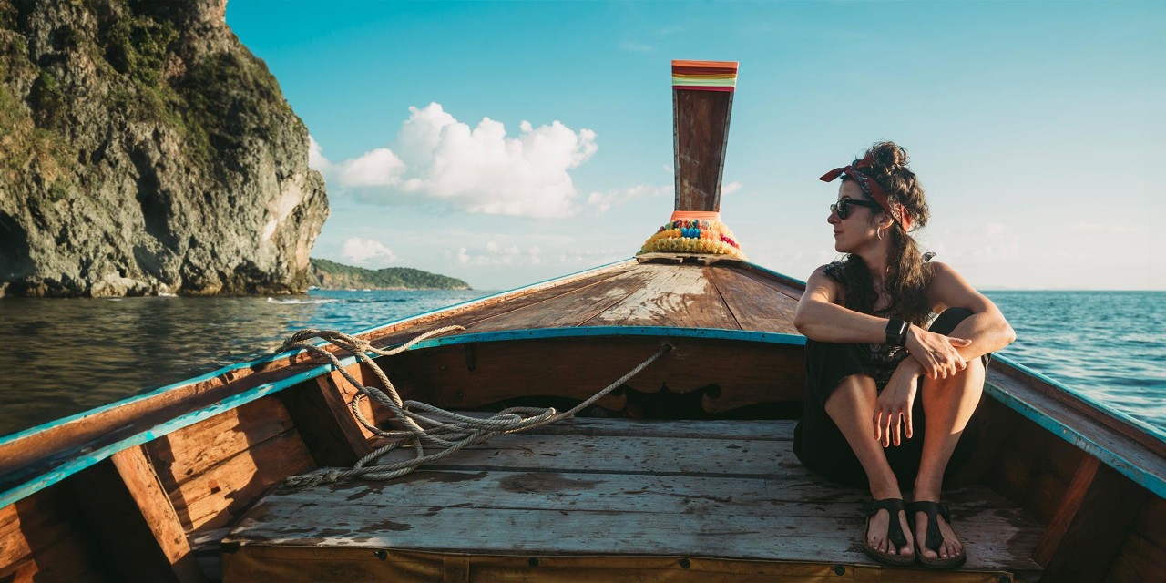Image of a woman sat in a boat at an exotic location