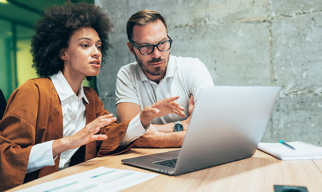 A man and woman discuss progress of a business loan application on a laptop, representing positive outcomes for borrowers with Royal Bank.