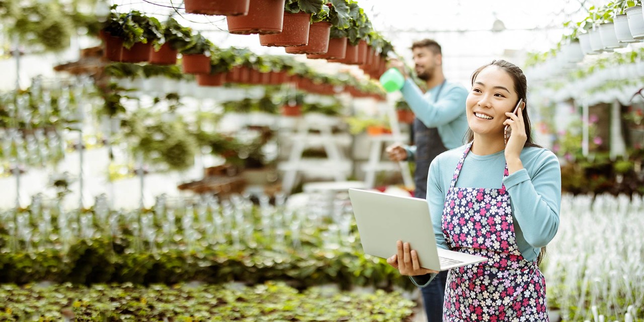 Supply chain issues being discussed on a construction site by three workers with a laptop.