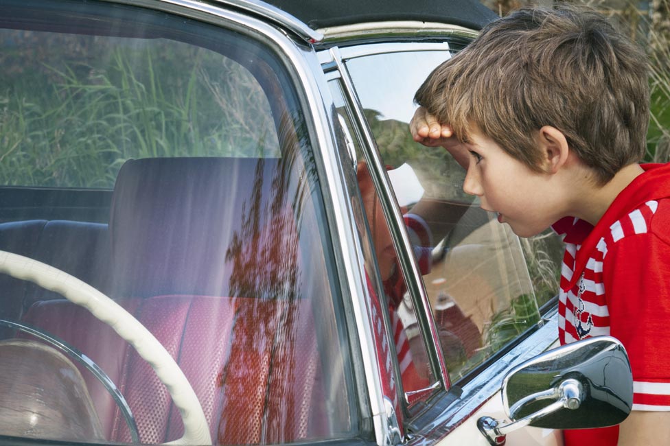 Boy looking in car window
