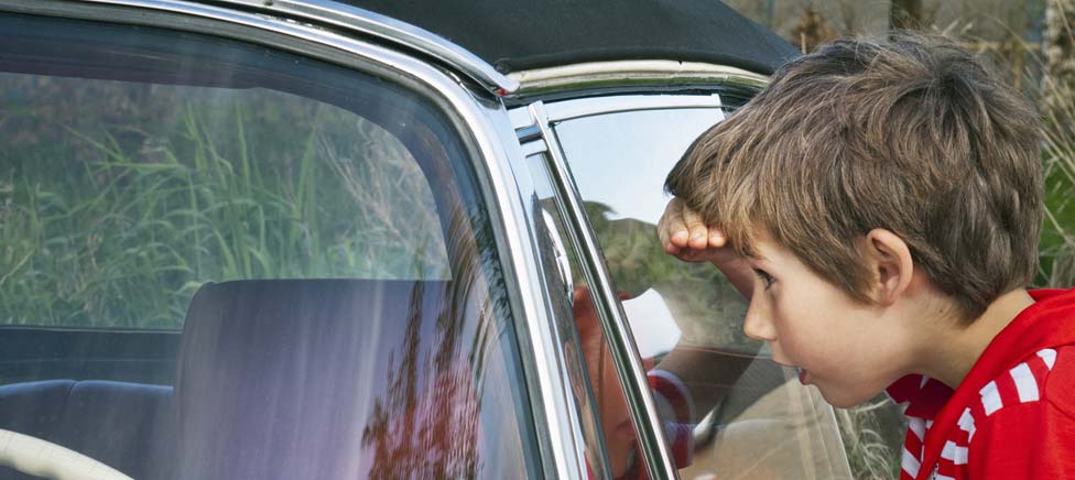 Boy looking in car window