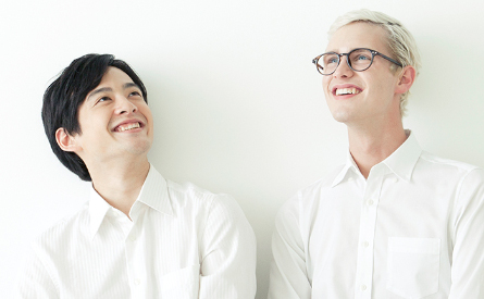 Photo of two smiling men wearing white shirts