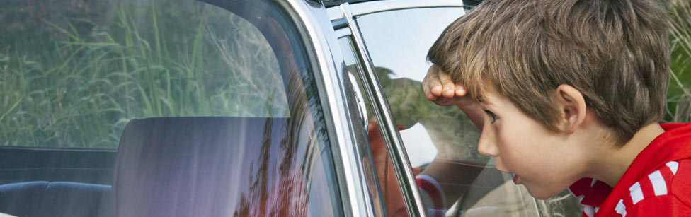 Boy looking into car window