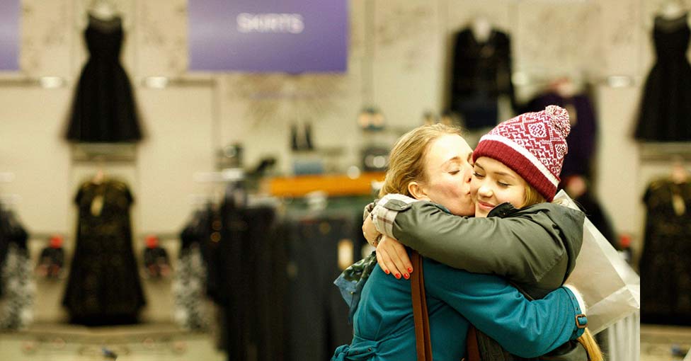 Two shoppers hugging