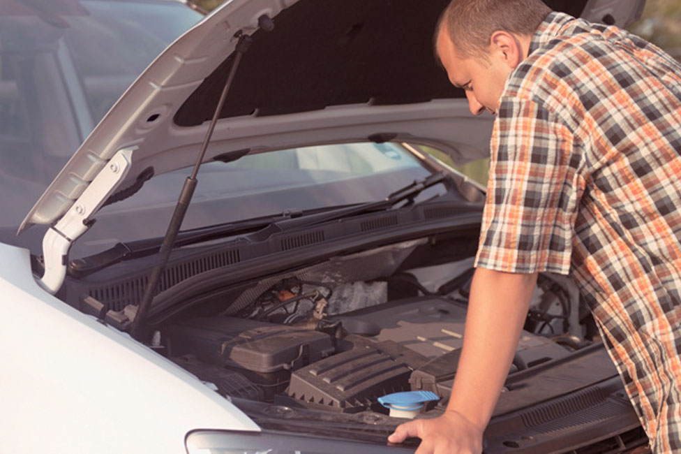 Man looking under bonnet of car