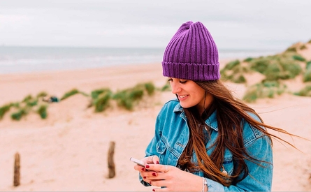 Girl looking at phone on beach