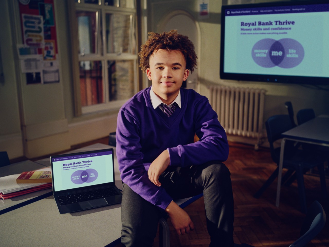 a boy with a laptop which says Royal Bank Thrive on the screen