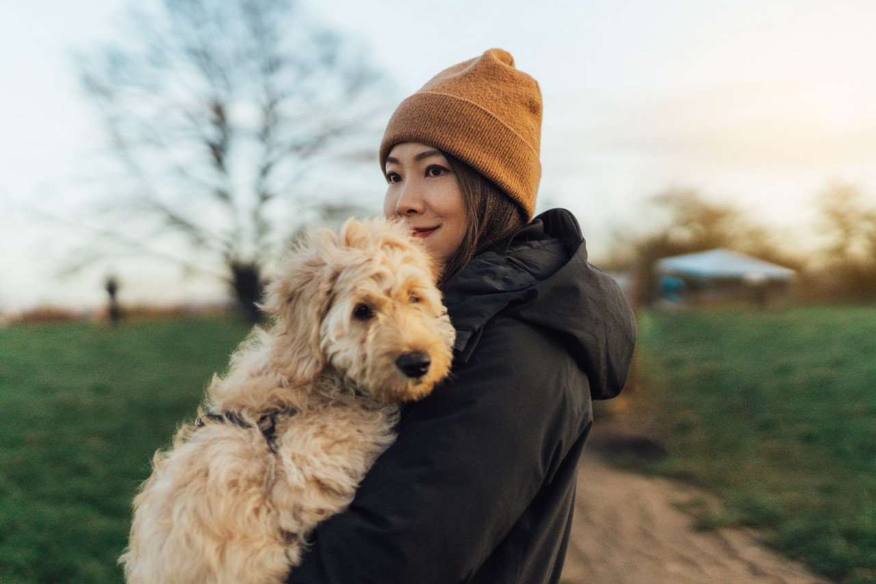 Portrait of a young woman walking with her dog at the park