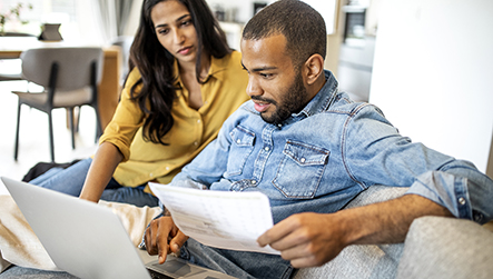young couple looking at a laptop photograph