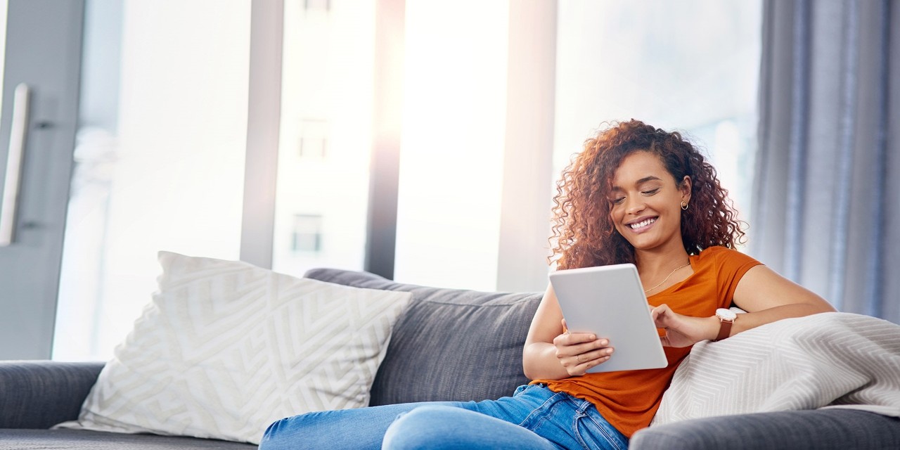 Woman sitting on couch with her iPad