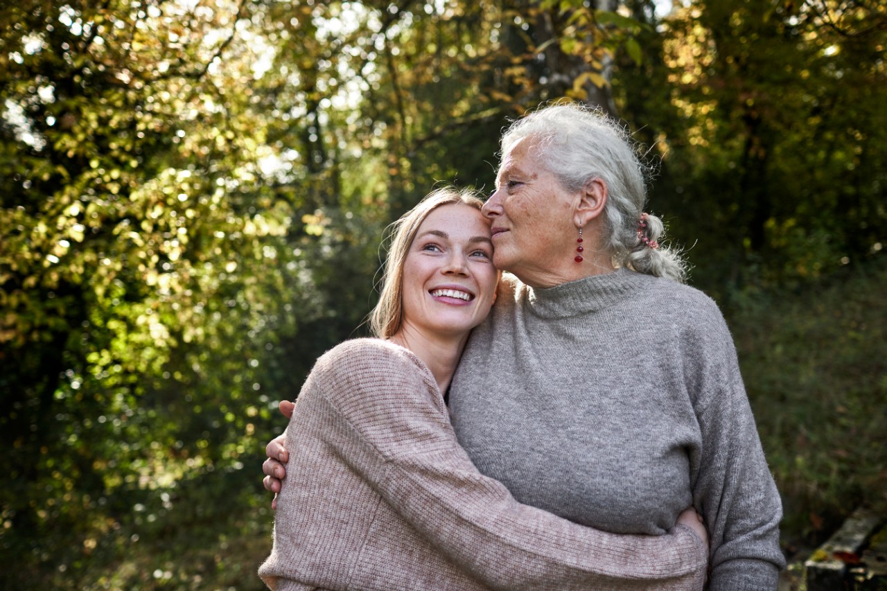 Older Mother and daughter embracing in the garden discussing NatWest Investment