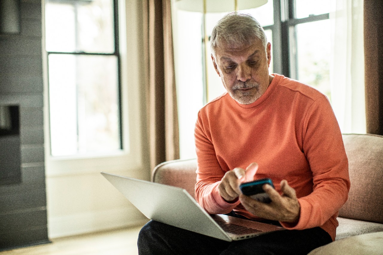 man working on laptop and phone