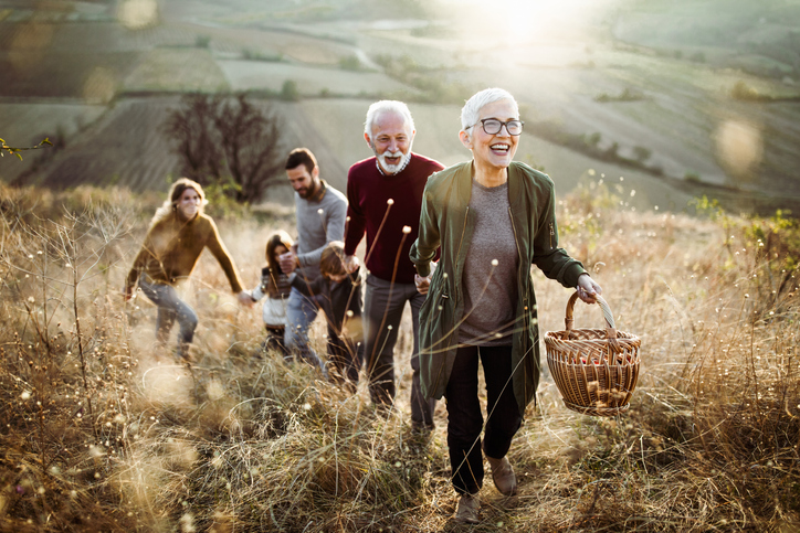 Three generations of a family walking up a scenic hill