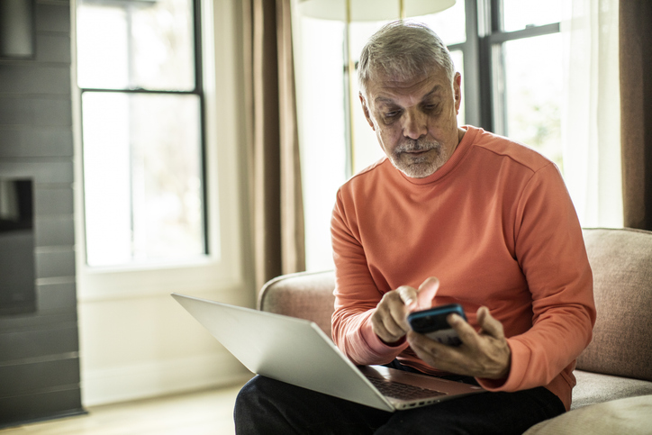 Man working on laptop and phone